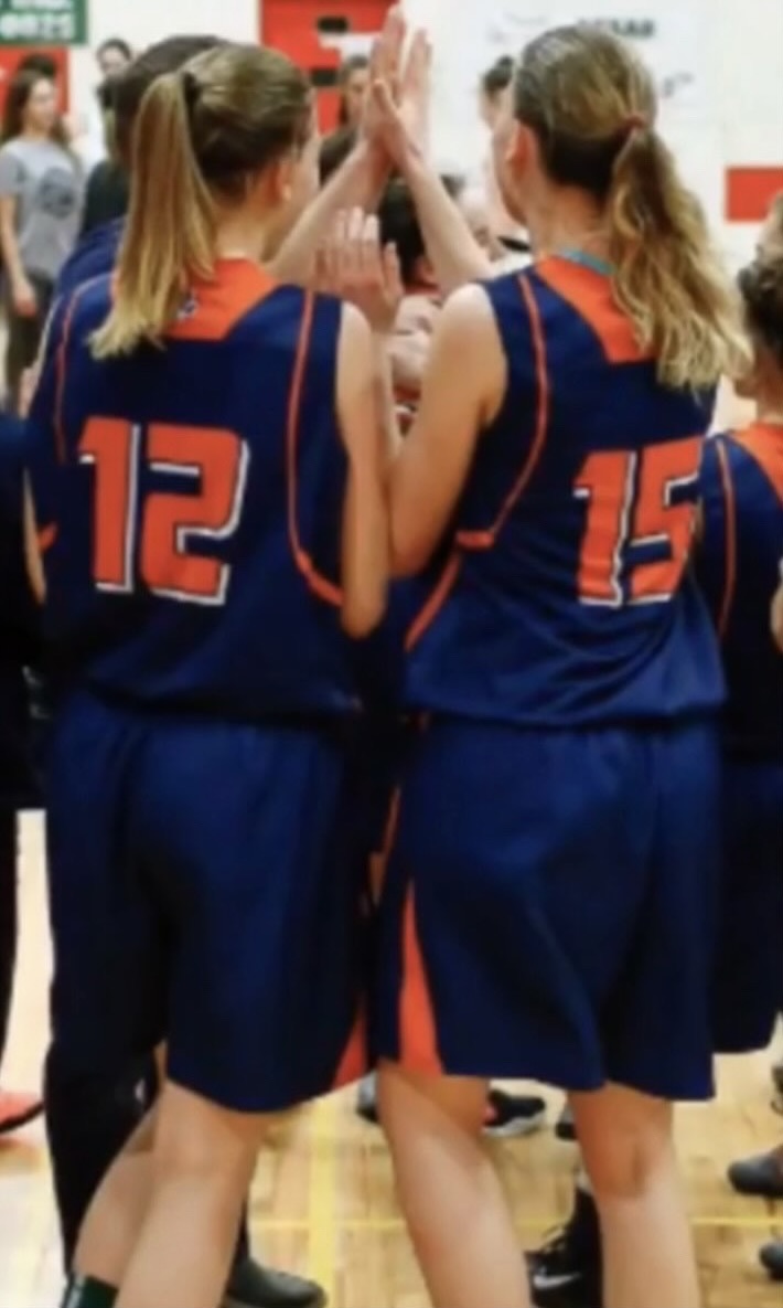 Sydney and Bailey during a timeout huddle on the court