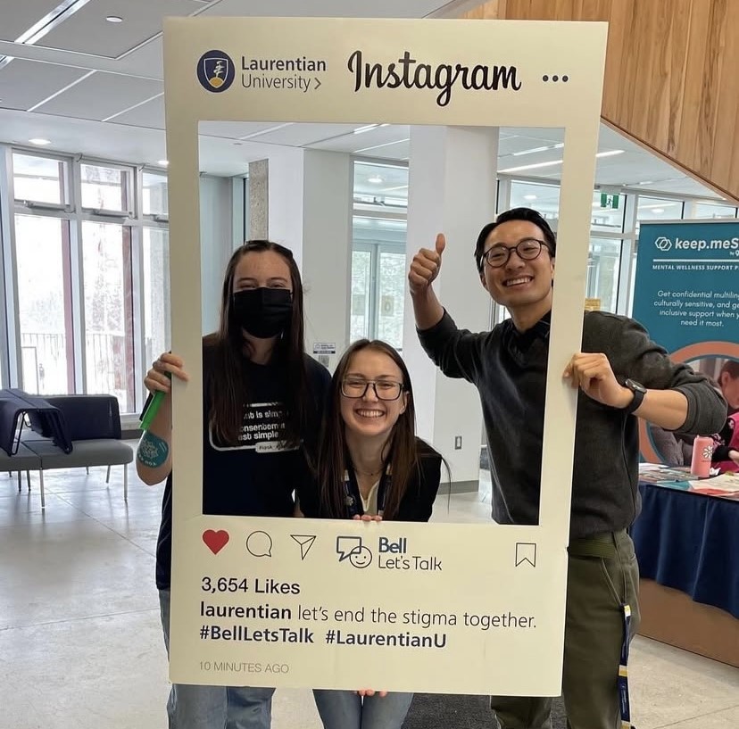 Picture of three students posing with a Bell Lets Talk prop