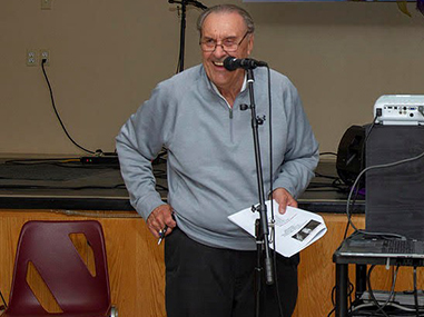 Gary J. Michalak talking through a microphone