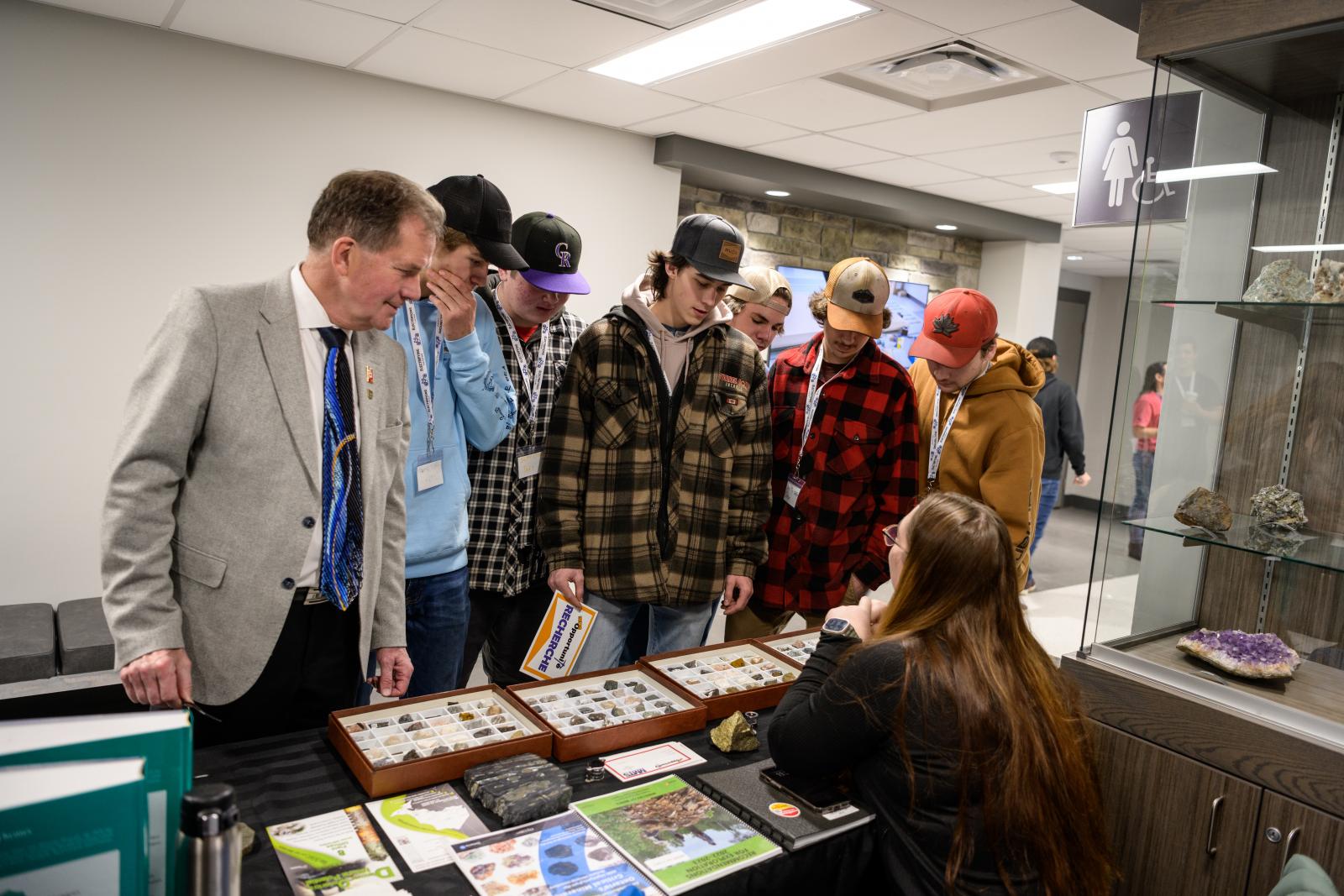 George Pirie, Minister of Mines and the MPP for Timmins joins students as they check out a rock and mineral display.