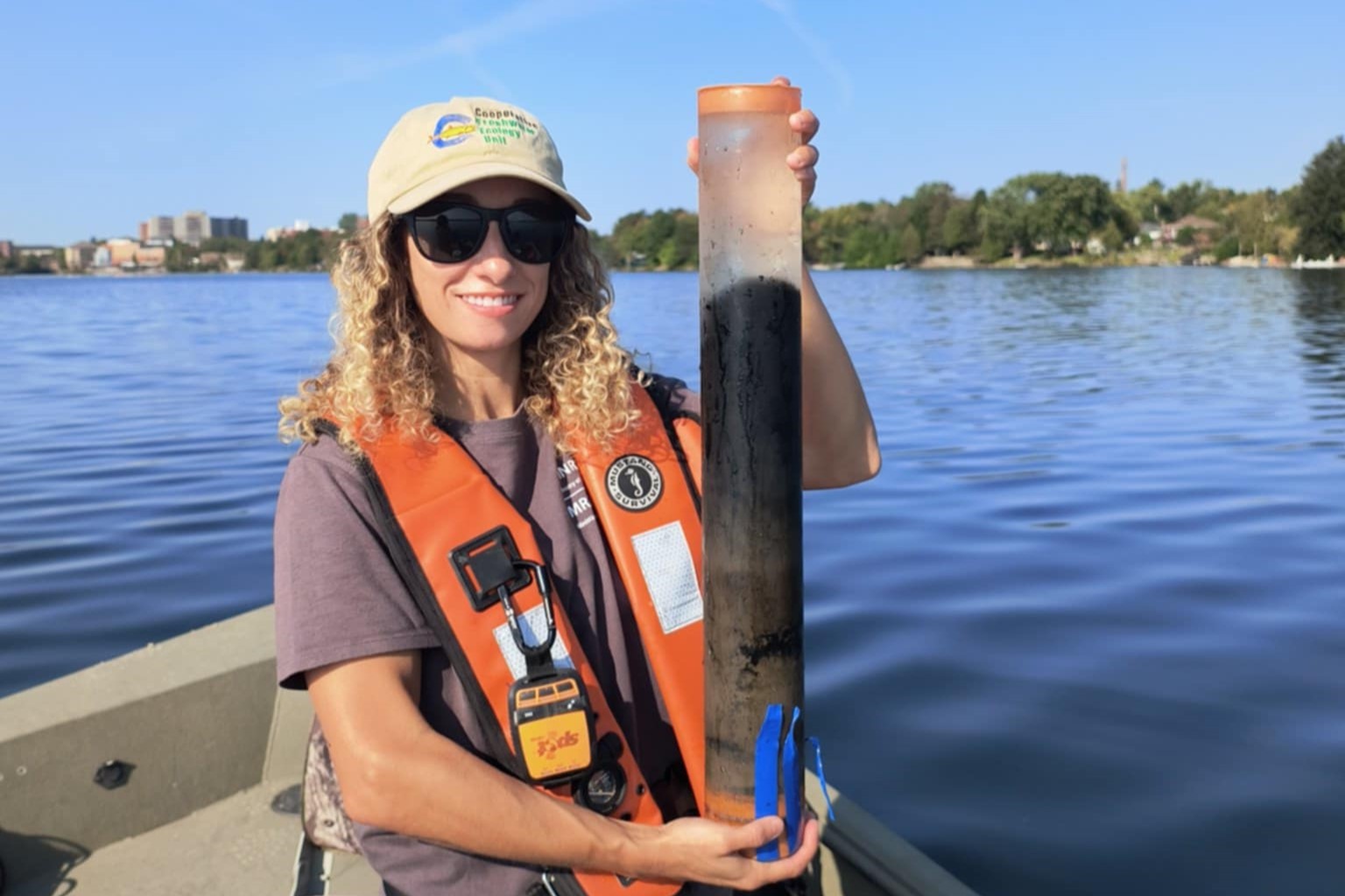 Elizabeth Favot holding a sediment core on a boat