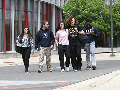 Five students walking on a pathway on the Laurentian campus.