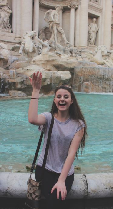 A person throwing a coin in the Trevi fountain