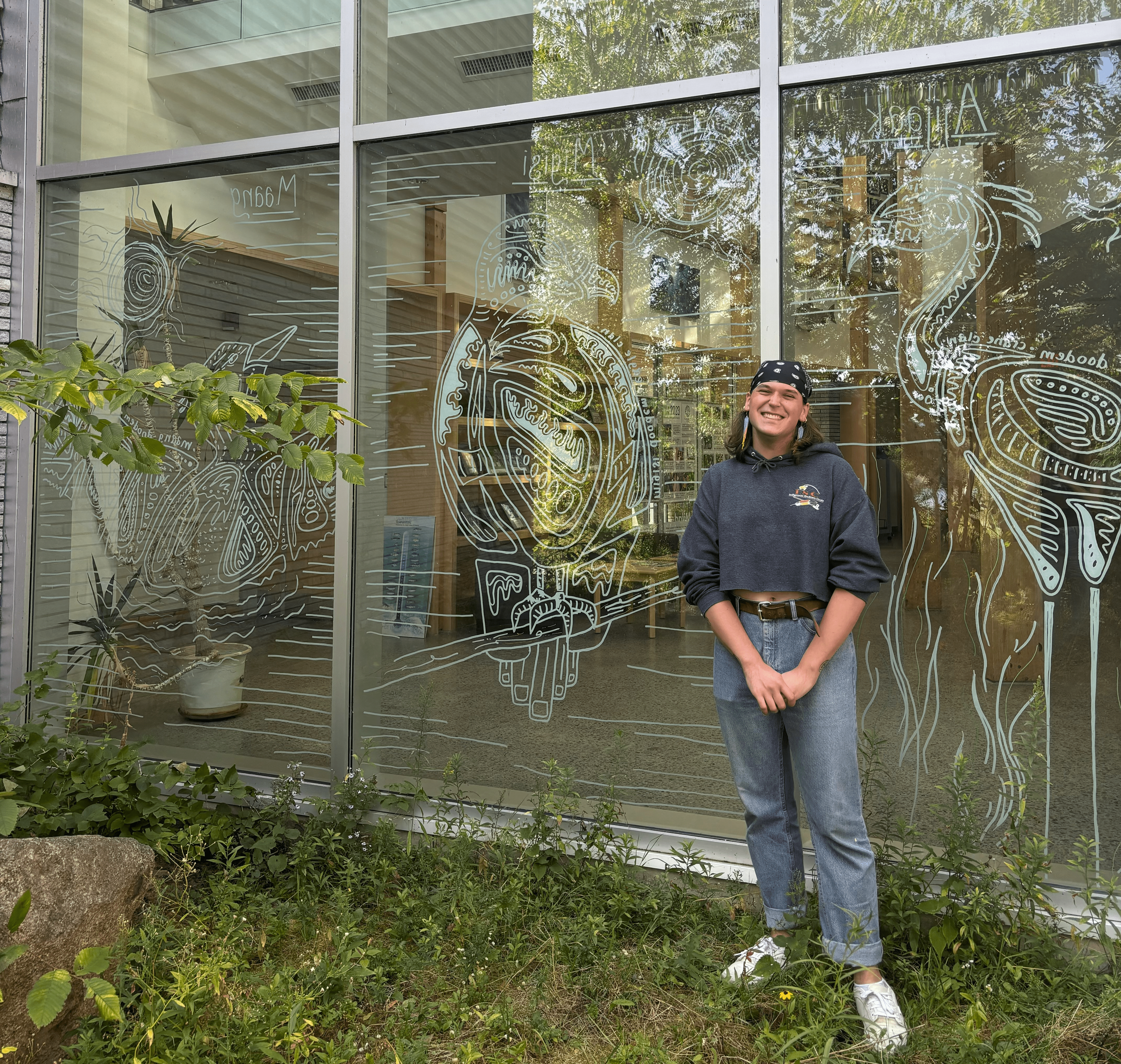 Person infront of window with bird drawings on it