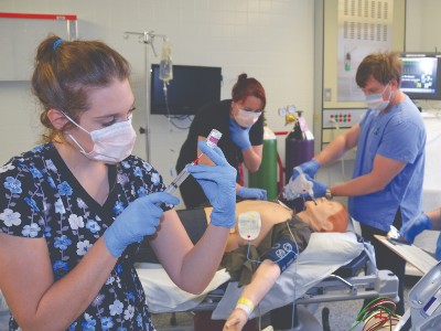 Several nurses around a dummy practicing