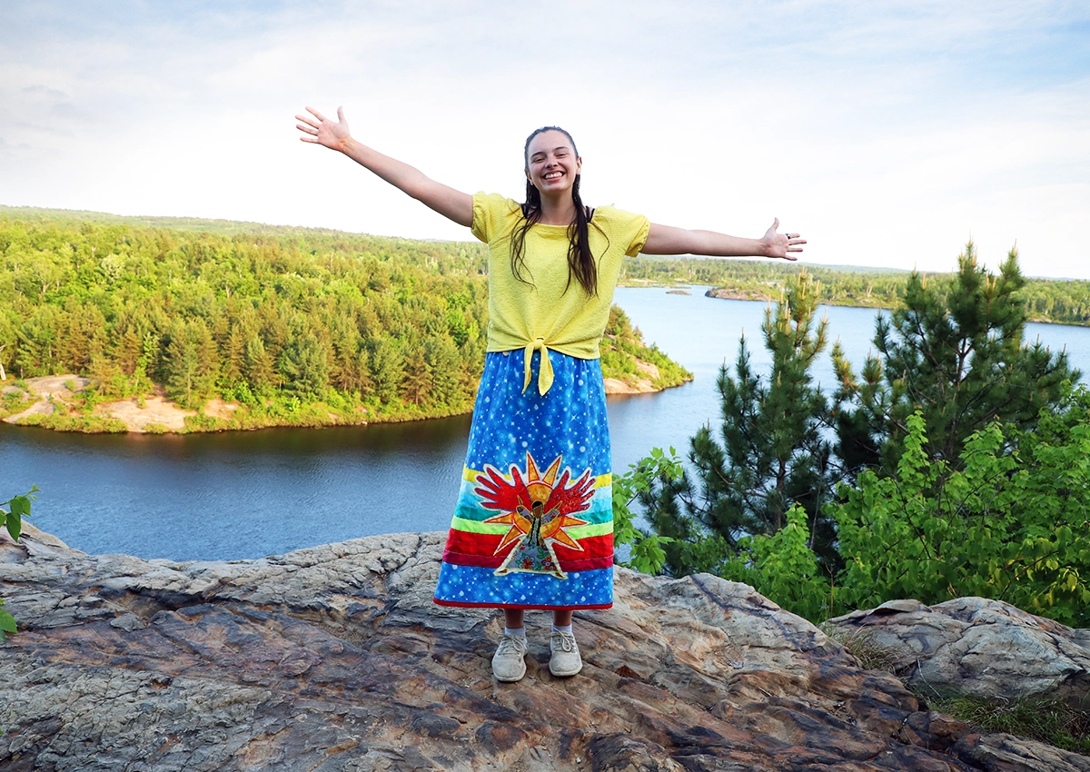 An Indigenous student in a ribbon skirt showcasing the nature on campus at Laurentian University.