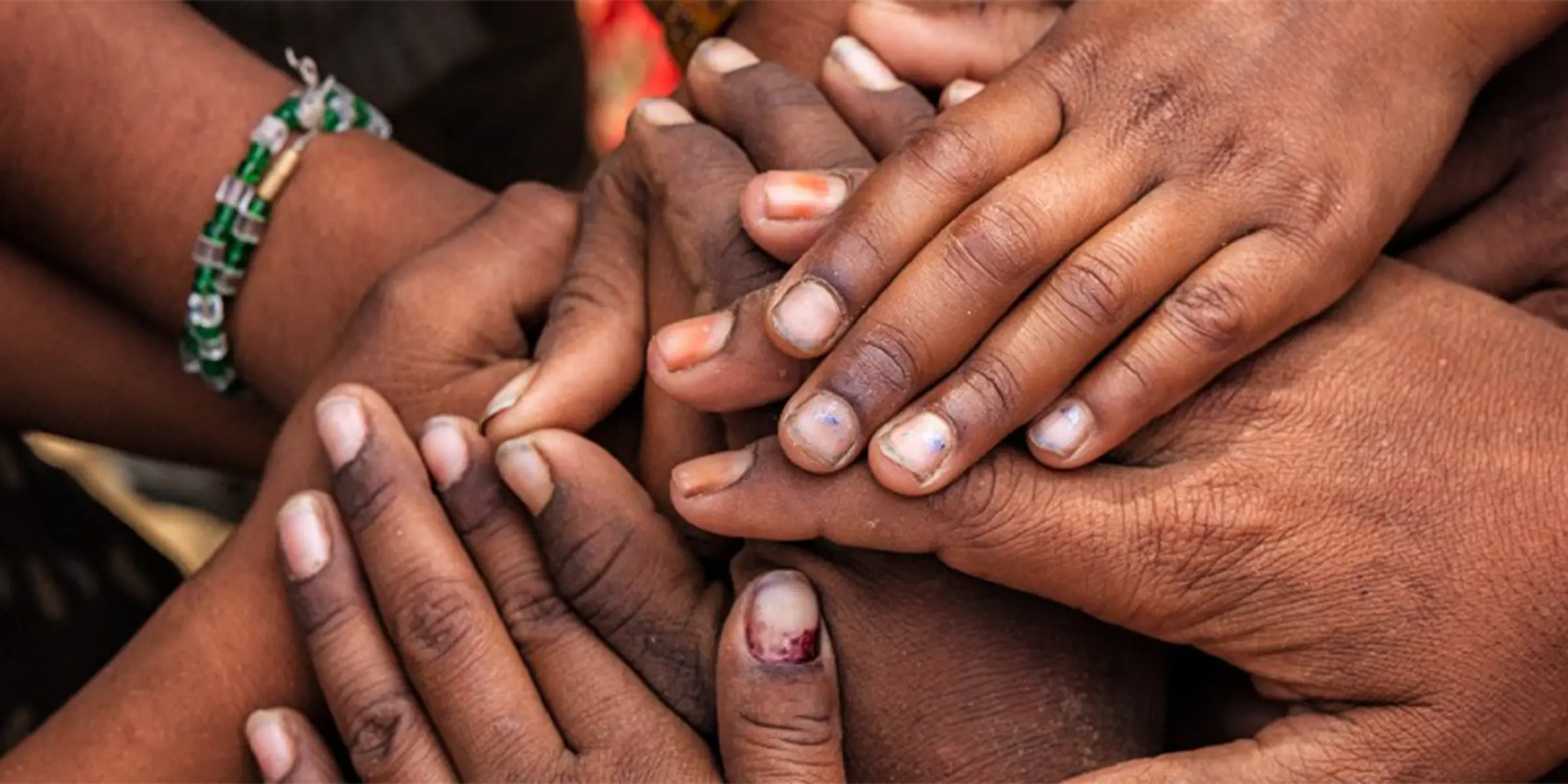 people's hands stacked on top of each other like they are about to do a cheer