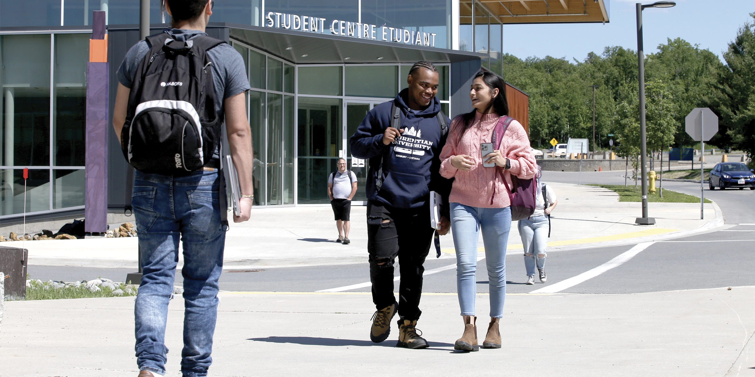 Two students walking in front of the Student Centre at Laurentian University.