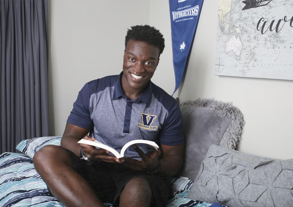 A student reading in his campus residence.