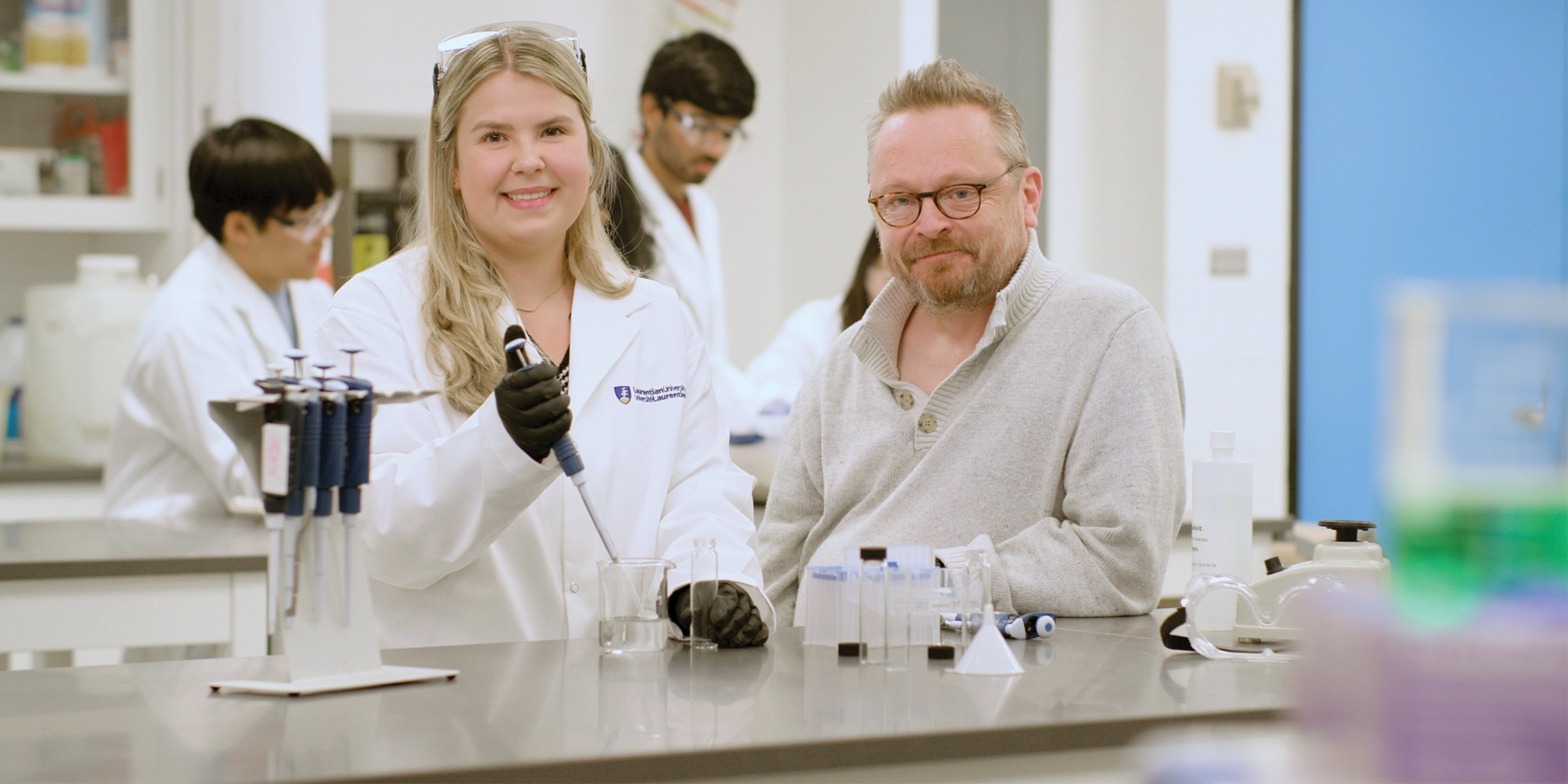 A student with a professor working in a science lab.