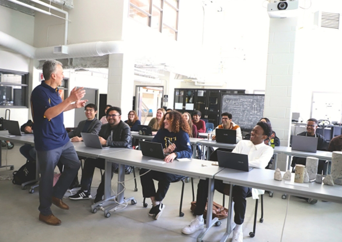 A professor teaching a lecture while students listen and take notes.