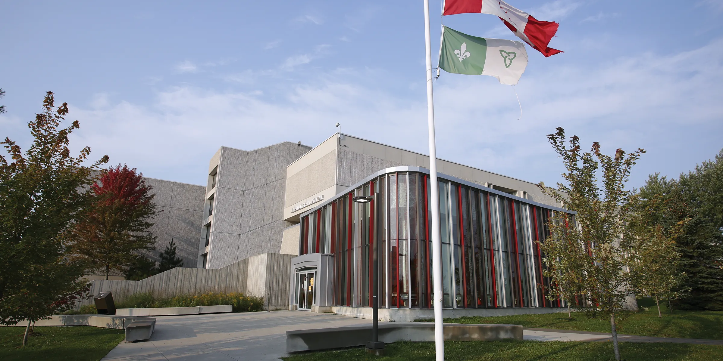 Alphonse Raymond building on Laurentian campus with Canadian and francophone flags