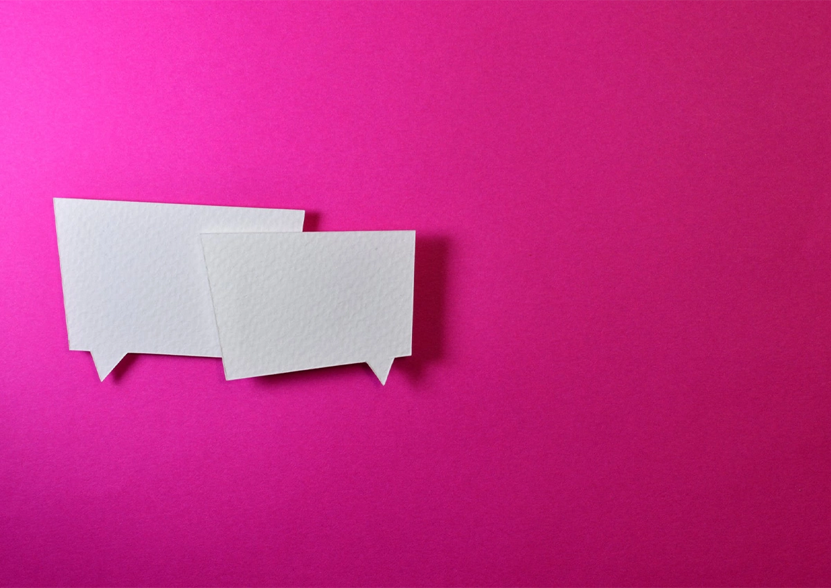 Two chat bubbles on a bright pink background.