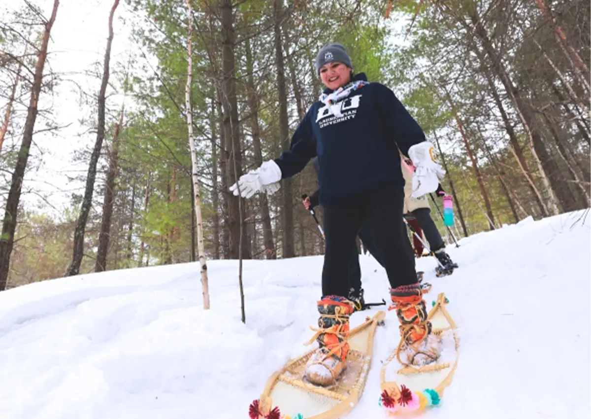 A Laurentian University student snowshoeing on campus.
