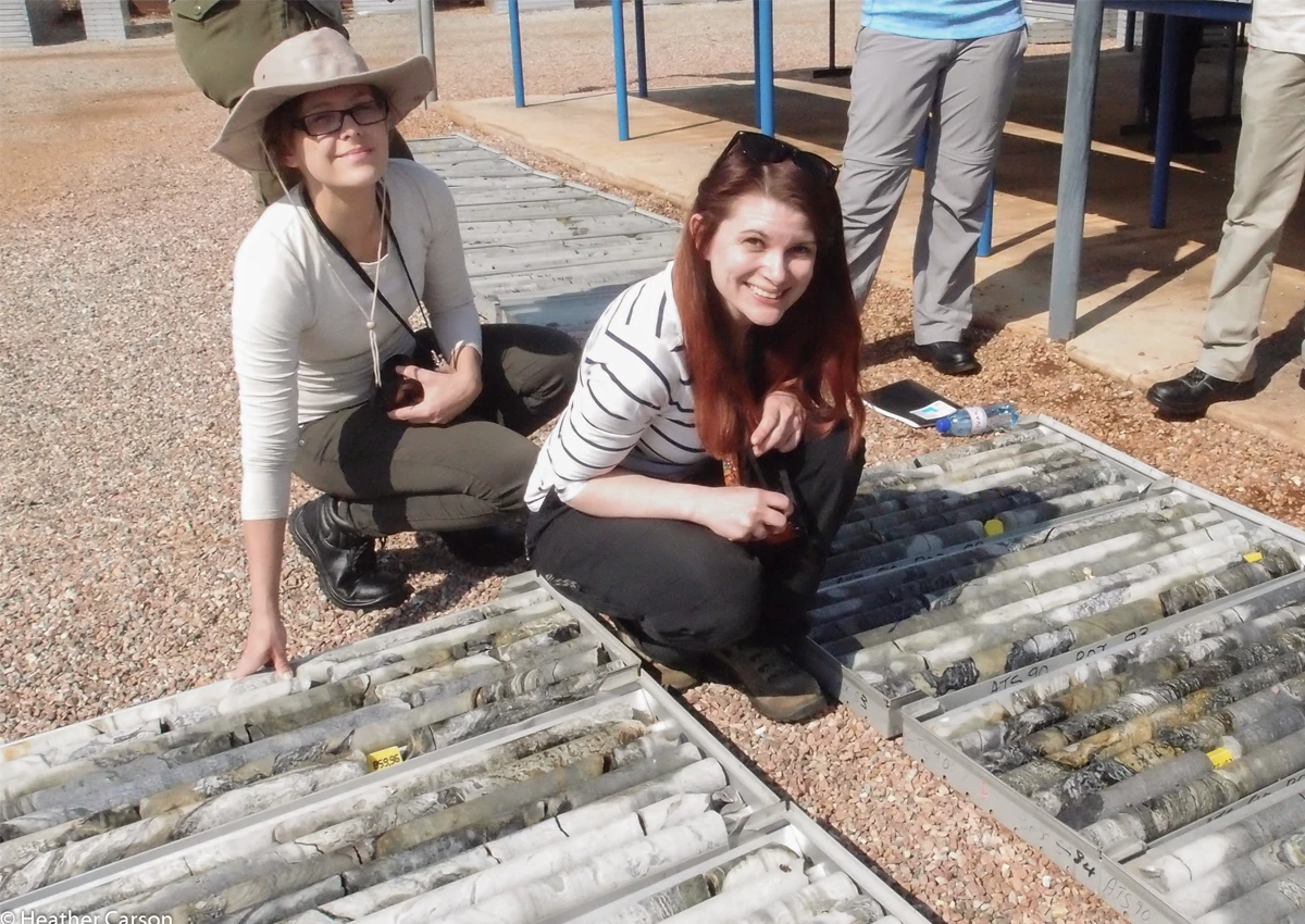 Two Earth Science students working outside, smiling.