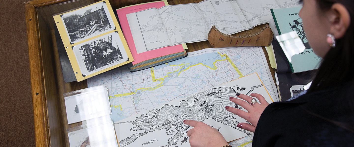 An Indigenous Laurentian University student studying an Indigenous map of Northern Ontario.