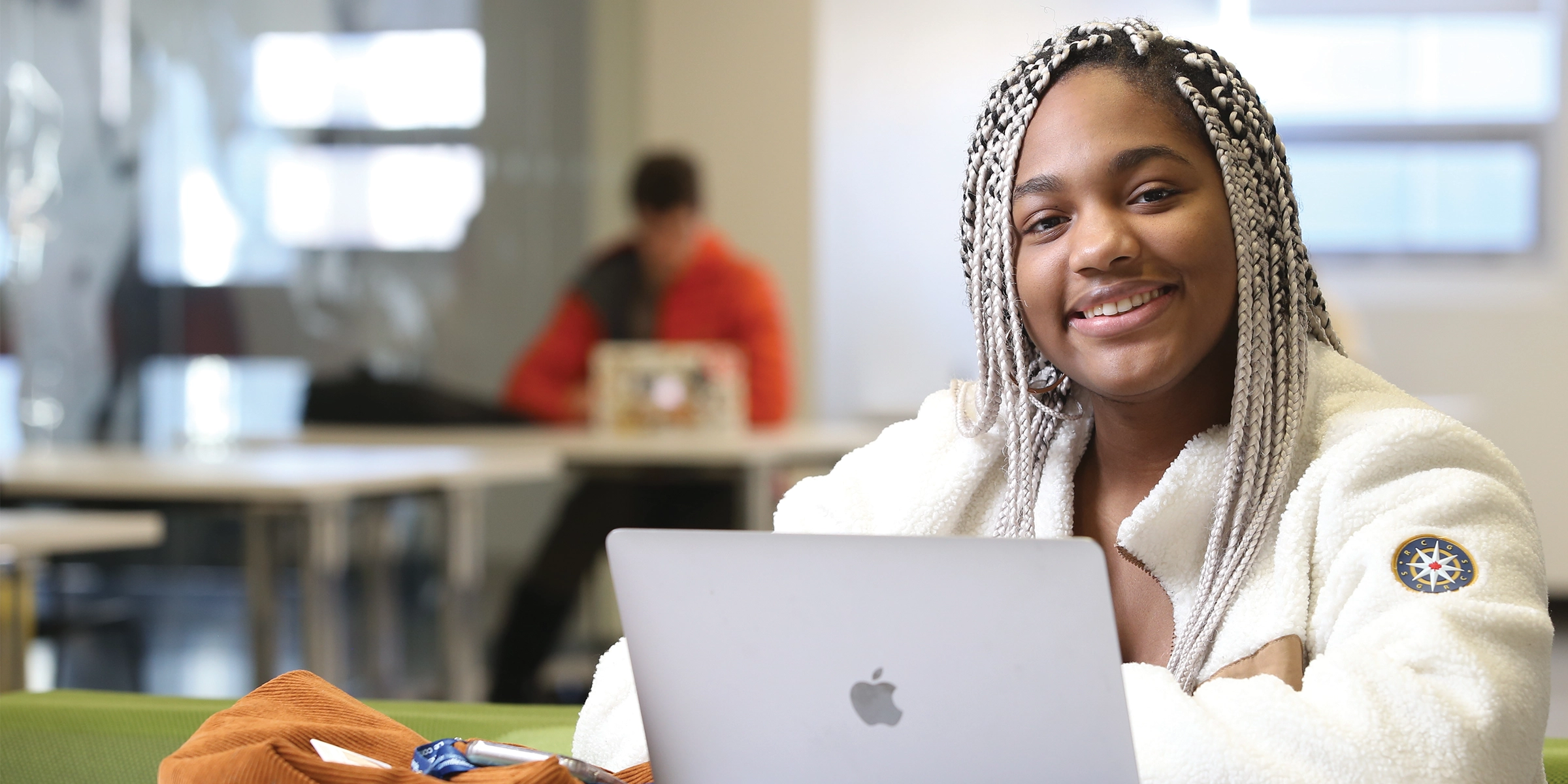 A Laurentian University student on her laptop in a study room.