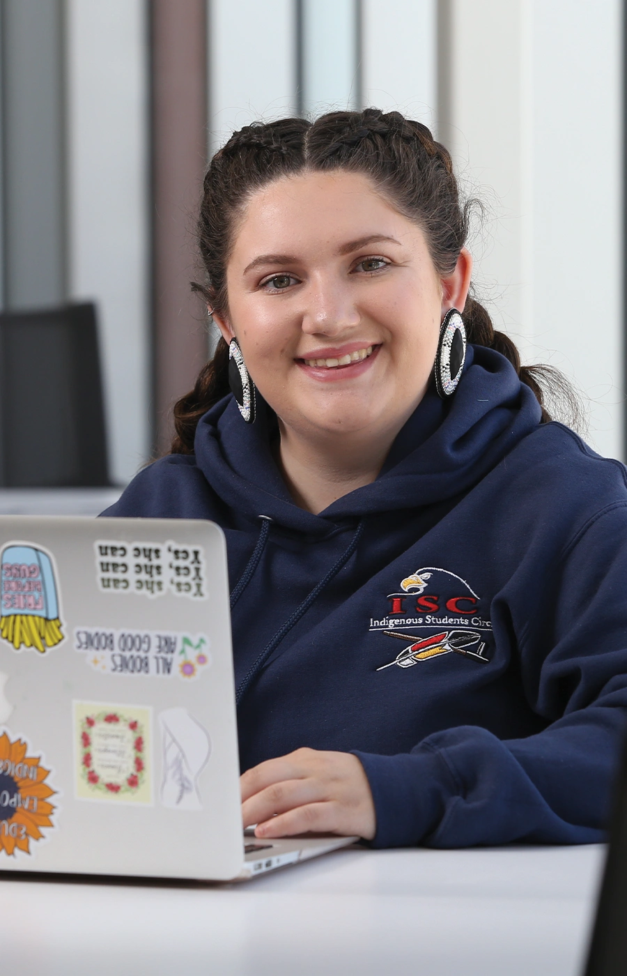 An international Laurentian University student on her laptop and smiling.