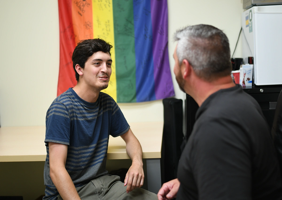 A Laurentian University student talking to someone in the LU Pride office.