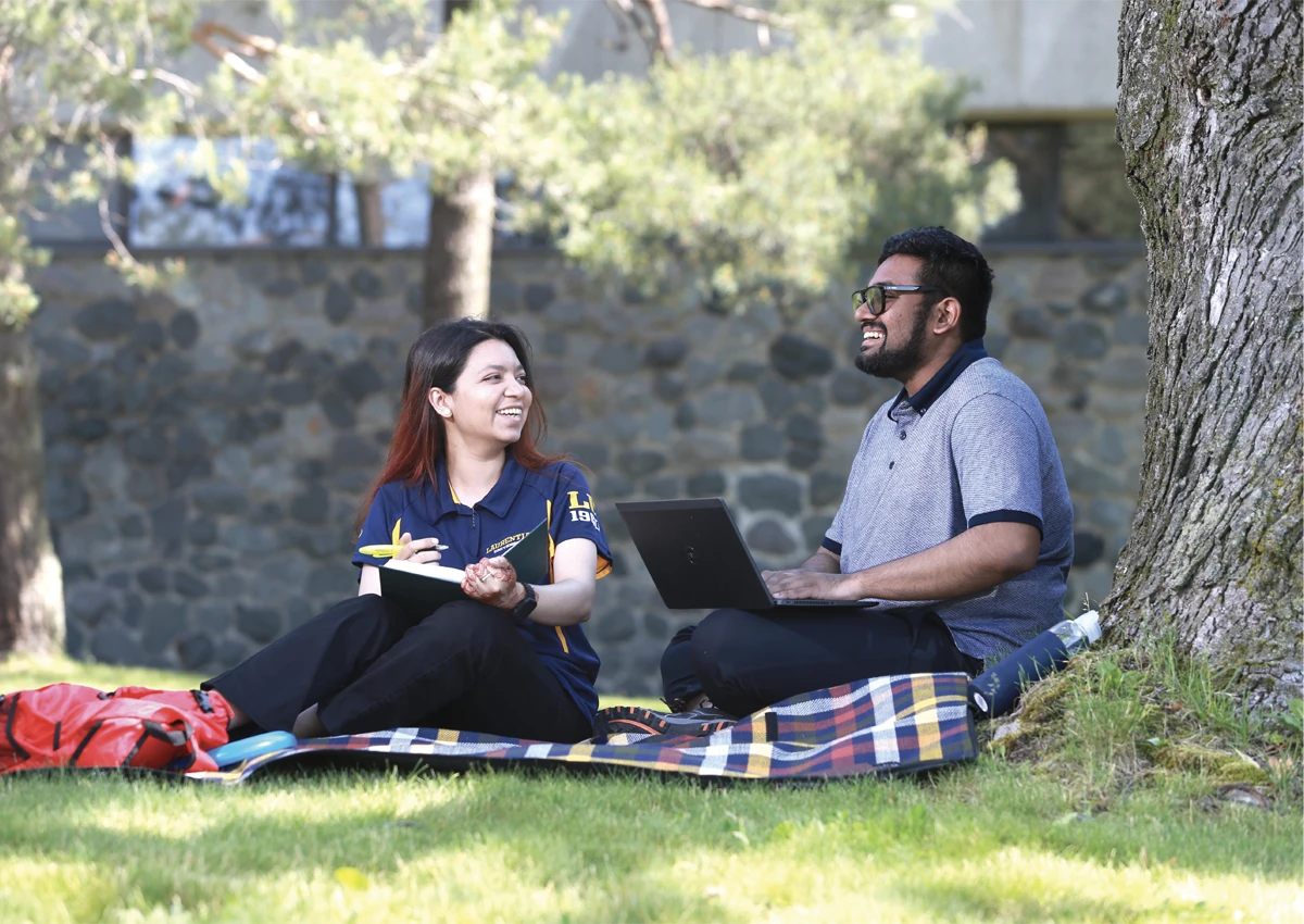 Two Laurentian University students studying together outside.