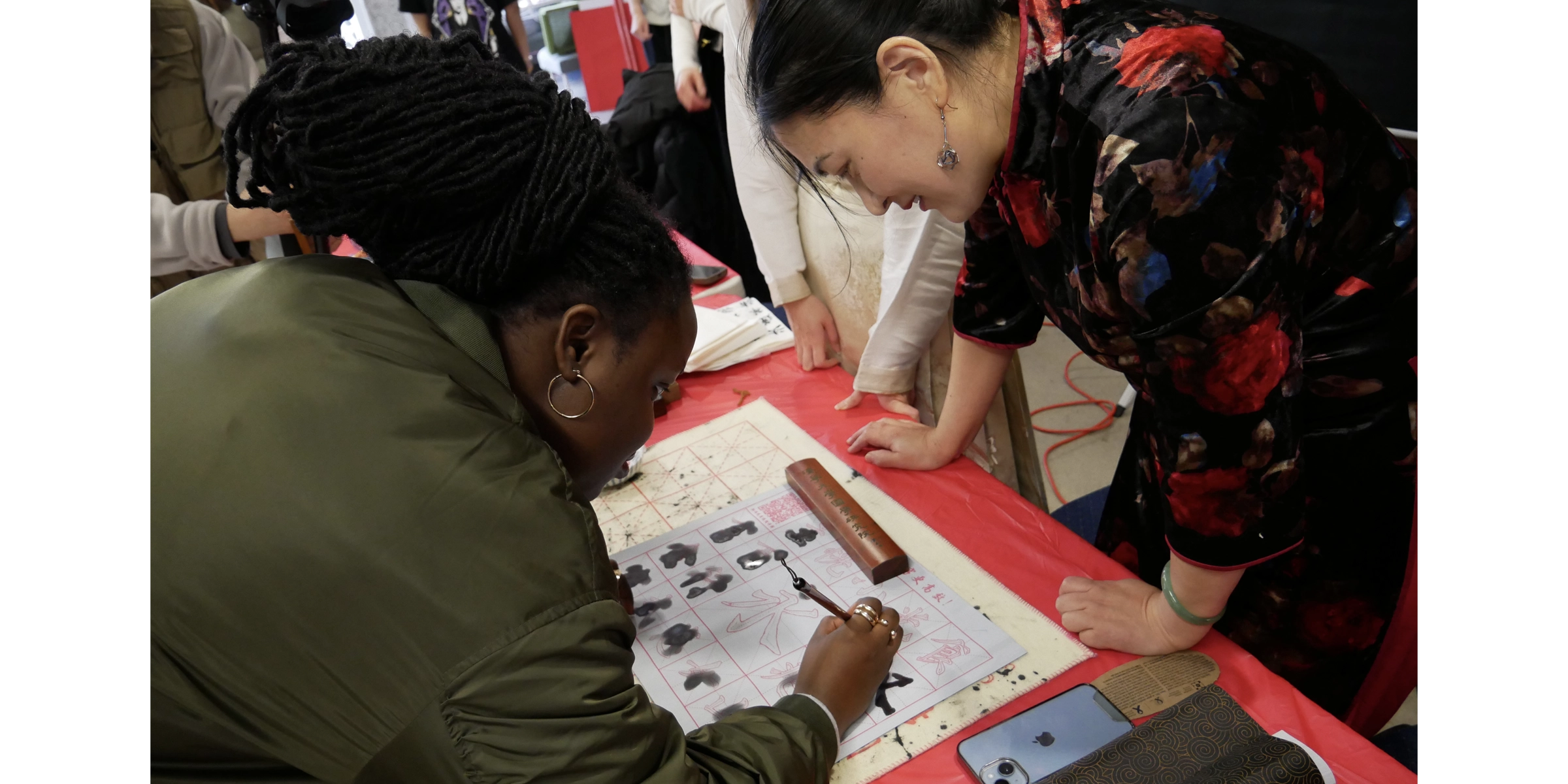 A member of the Laurentian community teaching someone how to paint Chinese calligraphy.