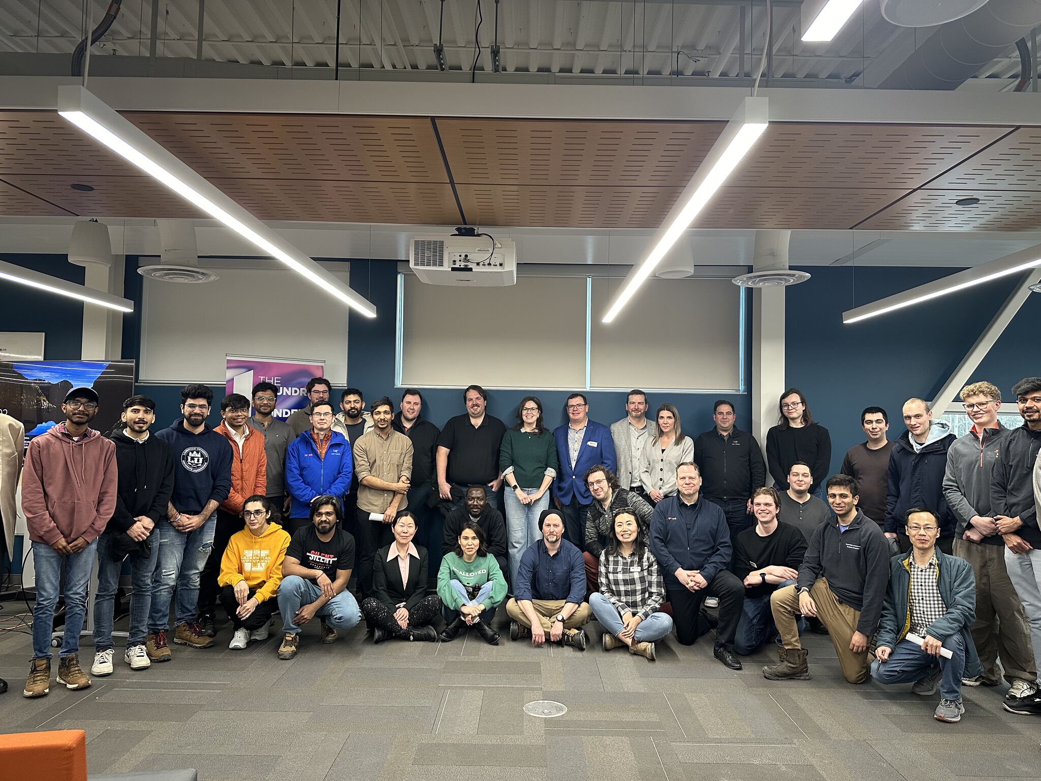30 people lined up for a photo in a big room
