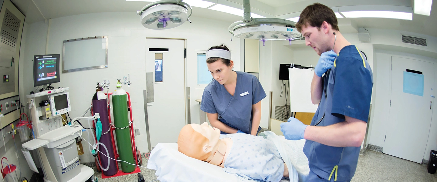 Laurentian University nursing students working in a nursing lab on a dummy patient.