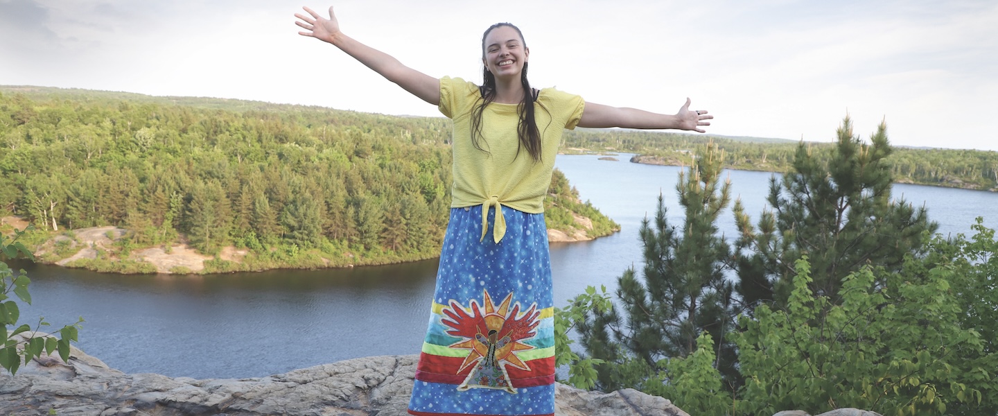 A woman posing in front of a lake