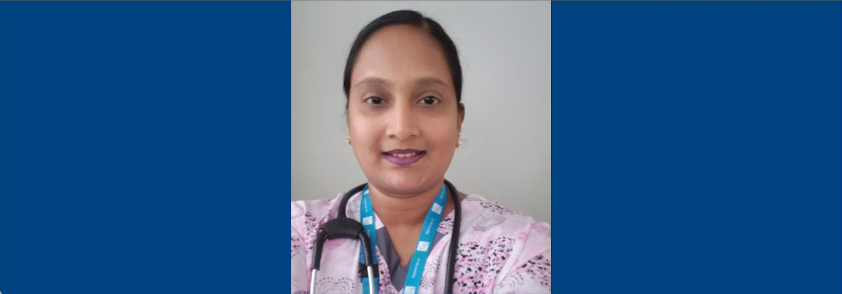 Portrait of healthcare professional Anisha Goodur Boodhoo in pink scrubs with a stethoscope.