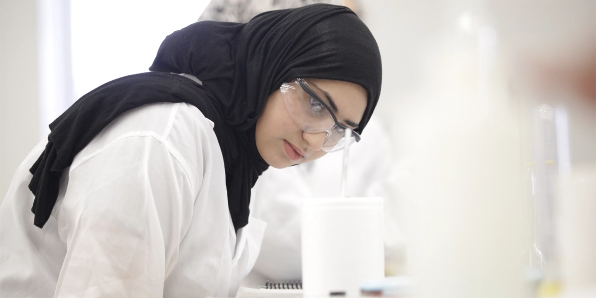 A chemical engineering student examining a sample in the lab.