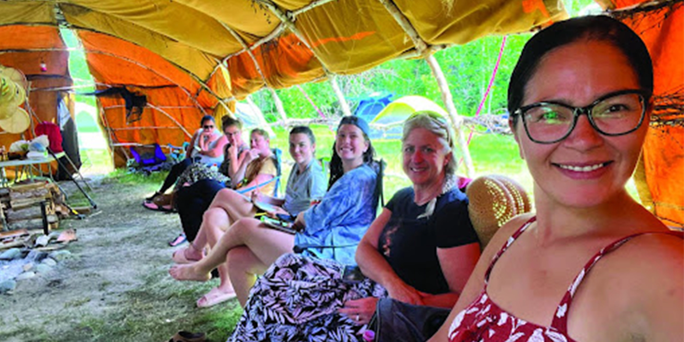 several women in sitting in a row smiling at a camera