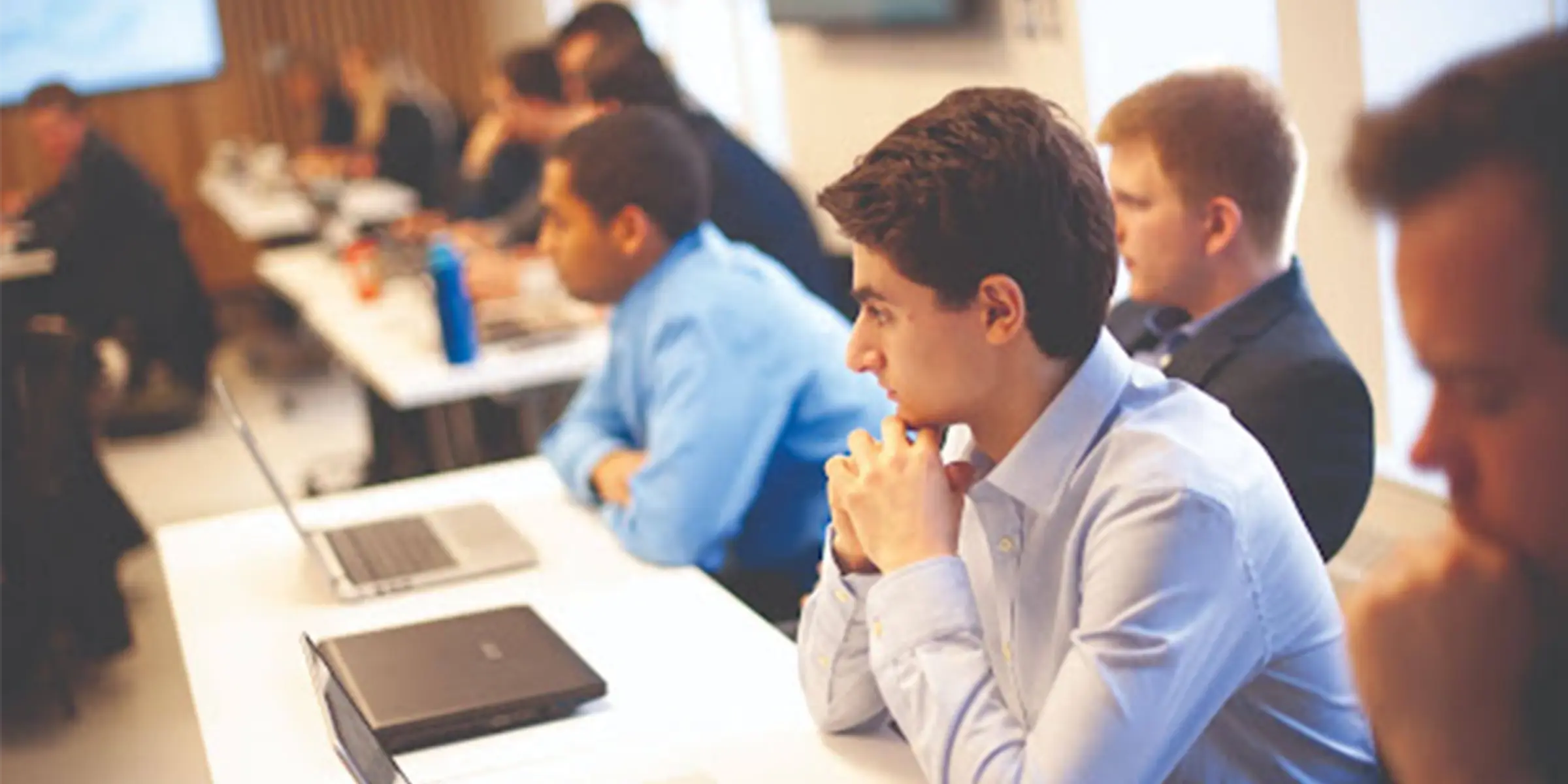 Student with laptop listening to lecture 
