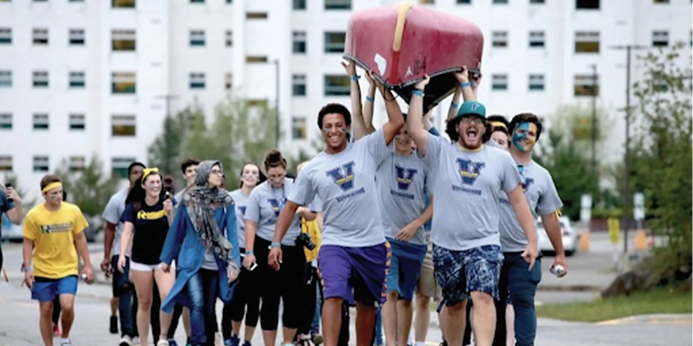 Students helping carry a canoe