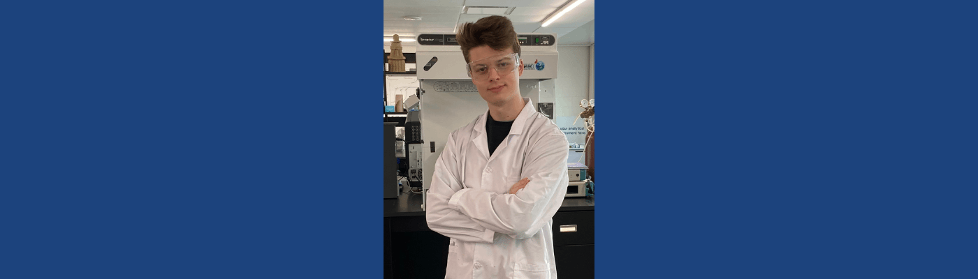 Ashtyn Mawbray-Mcmillan wearing lab coat and protective glasses