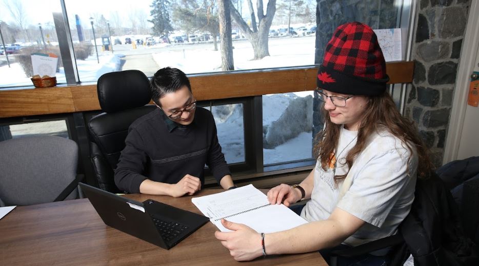 Peer Coach looking at student's notes