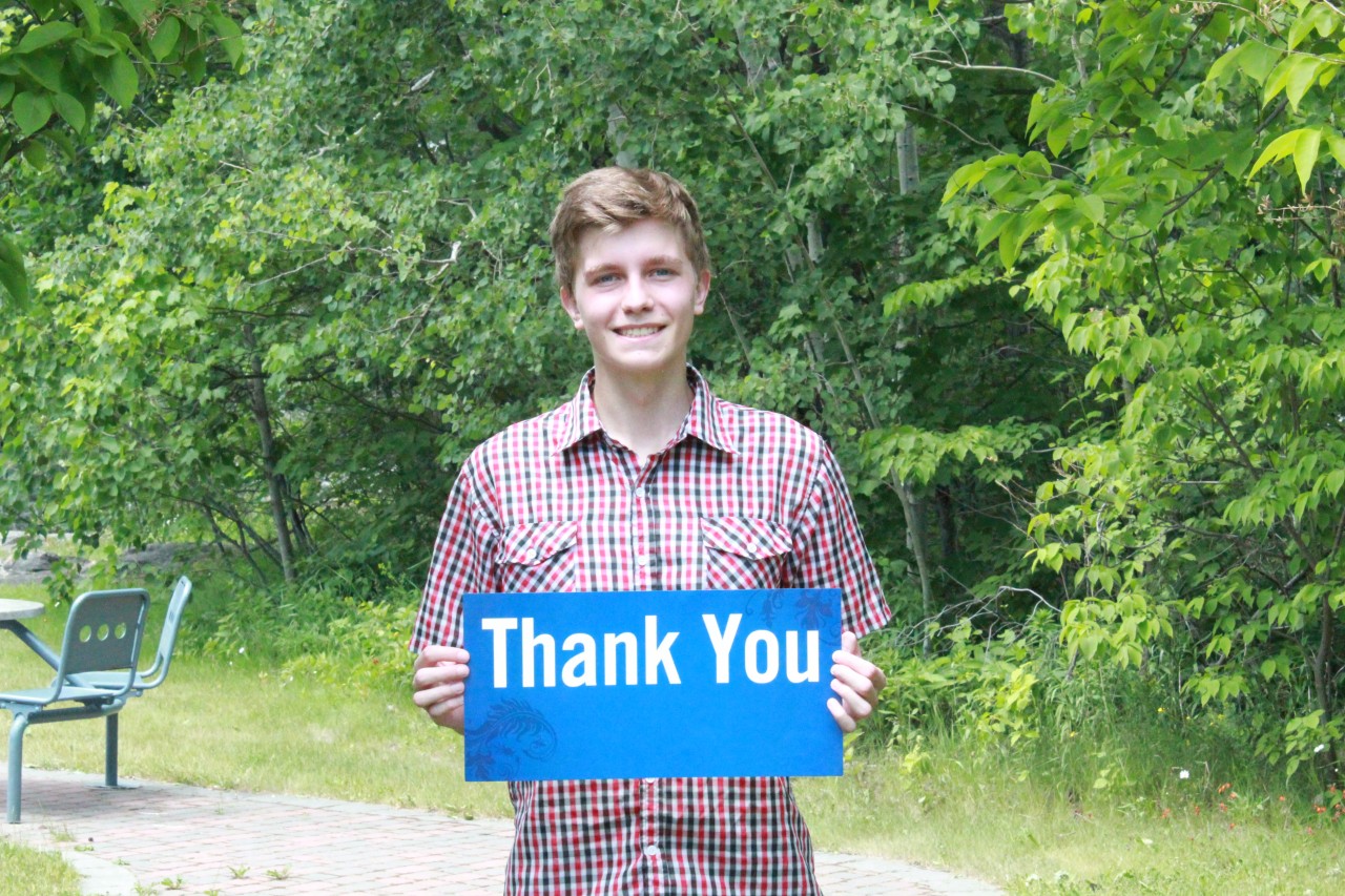 Student holding thank you sign