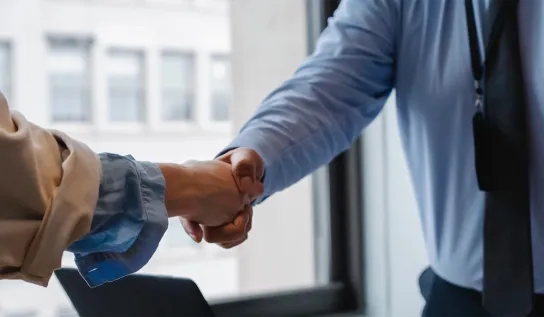 two people shake hands in an office