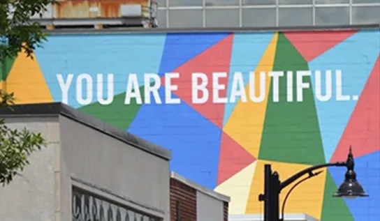A mural that reads "you are beautiful" painted on the side of a building in downtown Sudbury.