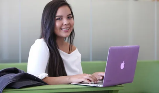 a girl sits in front of her computer in the parker building