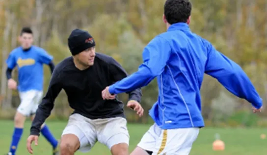 Men playing soccer on a field.