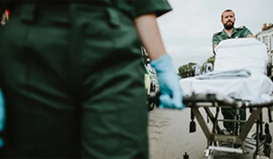A health care provider moving a patient bed