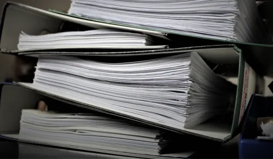 A stack of four large binders.