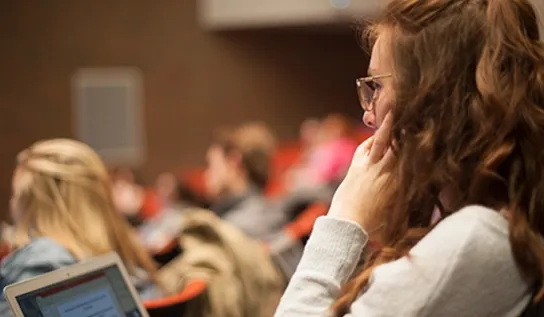 a student sits in a lecture in the fraser auditorium 