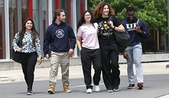 a group of students walk outside of the Indigenous Sharing and Learning Centre