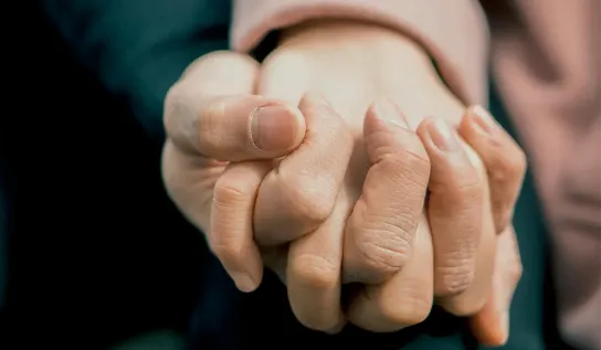 Closeup of 2 people holding hands