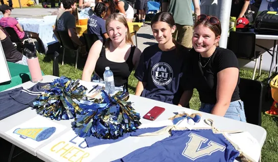 Three Laurentian University students at the LU Cheer Club table at the SGA clubs fair.