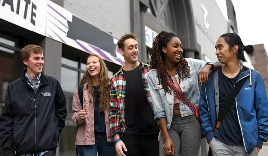 Laurentian University students walking and laughing together in downtown Sudbury.