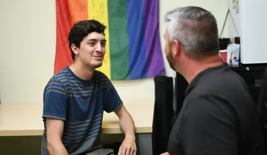 A Laurentian University student talking to someone in the LU Pride office.