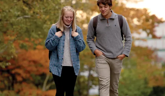 Two Laurentian University students walking on campus in the Fall.