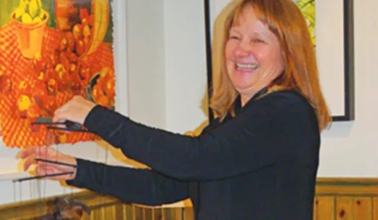 Brigitte Bere showcasing a piece of art of hers.